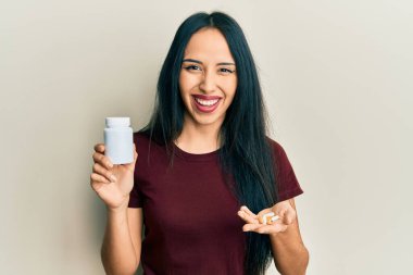 Genç İspanyol kız elinde haplarla gülüyor ve kahkahalarla gülüyor.. 