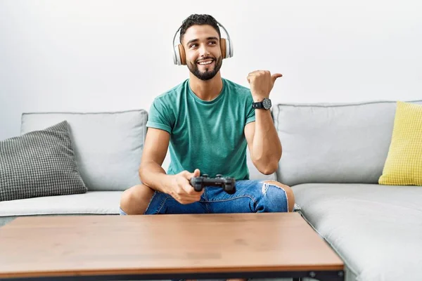 Snygg Hispanic Man Bär Hörlurar Spelar Spel Innehav Controller Pekar — Stockfoto