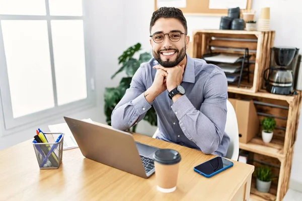 若いアラブ人男笑顔自信を持って使用してノートパソコン作業でオフィス — ストック写真