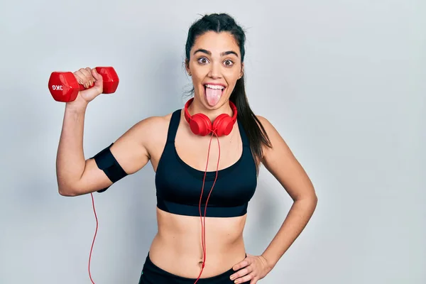 Joven Chica Hispana Usando Ropa Deportiva Usando Mancuerna Sacando Lengua — Foto de Stock