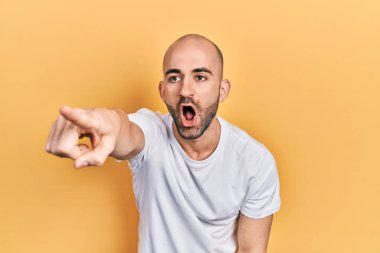 Genç kel adam, günlük beyaz t-shirt giyiyordu. Parmağıyla işaret ediyordu. İleriyi gösteriyordu. 