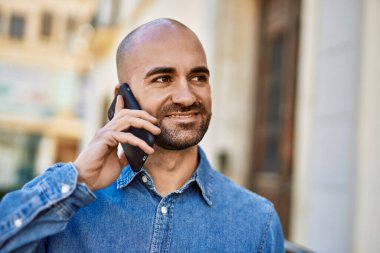 Genç İspanyol adam gülümsüyor. Şehirdeki akıllı telefondan konuşuyor..