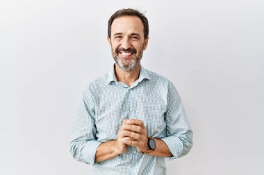 Orta yaşlı, sakallı bir İspanyol adam arka planda el ele tutuşup gülümseyerek gevşemiş ve neşeliydi. Başarı ve iyimserlik 