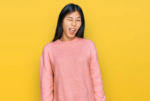 美しいです若いですアジアの女性身に着けていますカジュアル冬のセーターウインク見ますザ カメラとともにセクシー表現 陽気で幸せな顔 — ストック写真