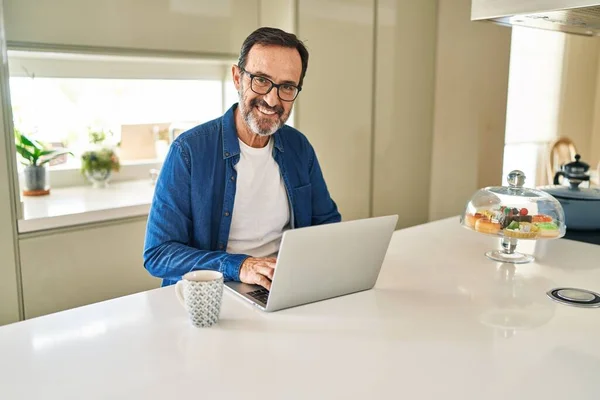 Mężczyzna Średnim Wieku Uśmiechnięty Pewnie Pomocą Laptopa Domu — Zdjęcie stockowe