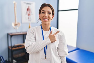 Genç esmer kadın ağrı giderme kliniğinde çalışıyor. Neşeli, yüzünde gülücüklerle mutlu ve doğal bir ifadeyle elini ve parmağını kaldırıyor. 