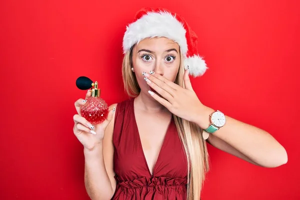 Menina Loira Jovem Usando Chapéu Natal Segurando Doces Cobrindo Boca — Fotografia de Stock