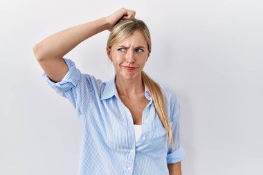 Beyaz arka planda duran güzel sarışın kadın soru sorup kafasını karıştırıyor. Şüpheyle kararsız, kafa kafaya düşünerek. Düşünceli kavram. 