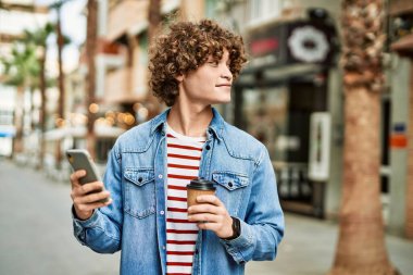 Genç İspanyol adam şehirde akıllı telefon kullanıyor.