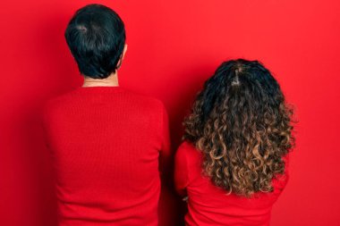 Orta yaşlı bir çift İspanyol kadın ve erkek birbirine sarılıyor ve arkasını dönüp kollarını kavuşturup bakıyorlar. 