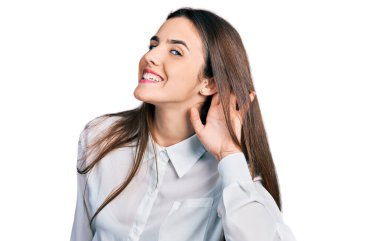 Genç esmer genç iş adamı beyaz tişörtü giymiş, ağzı kulaklarına varan bir gülümsemeyle dedikoduları ve dedikoduları dinliyor. Sağırlık kavramı. 