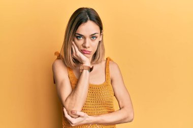 Sarışın, sıradan bir tişört giyen genç bir kadın kollarını kavuşturup depresyondan sıkılmış ve yorgun görünüyor.. 