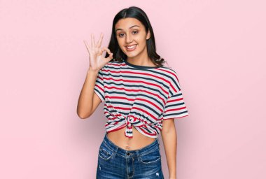 Gündelik kıyafetler giyen, gülümseyen genç İspanyol kız el ve parmaklarıyla 