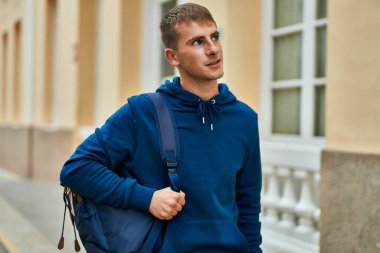 Üniversitede mutlu bir şekilde gülümseyen genç sarışın öğrenci..