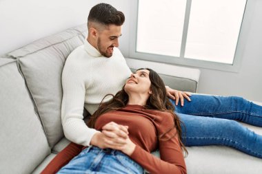 Genç İspanyol çift kanepede ve evde sarılıp dinleniyorlar..