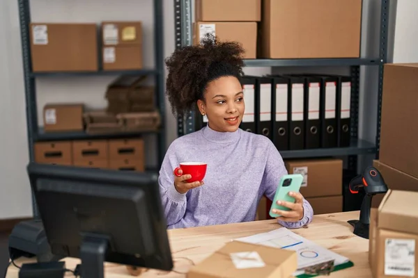 年轻的非洲裔美国女性电子商务工作者在办公室用智能手机喝咖啡 — 图库照片