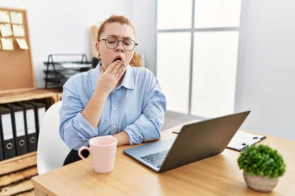 Young Redhead Woman Working Office Using Computer Laptop Bored Yawning —  Fotos de Stock