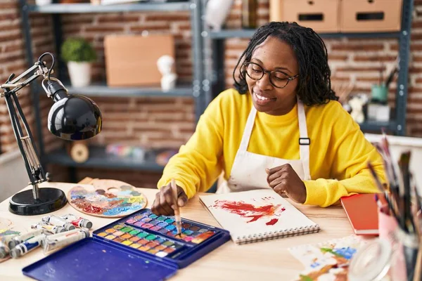 在艺术工作室 非洲裔美国女艺术家自信地微笑在笔记本上画画 — 图库照片
