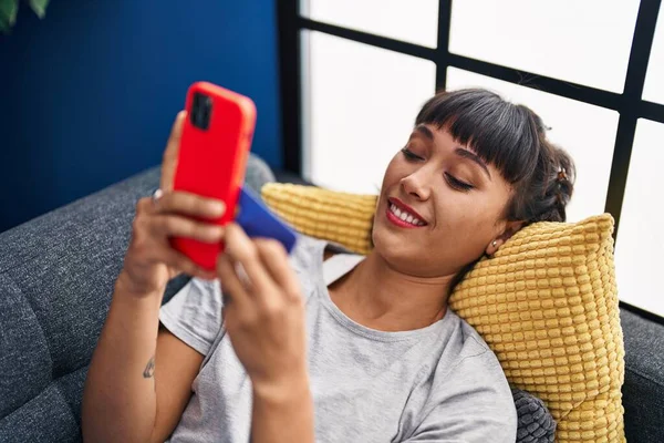 Jovem Mulher Usando Smartphone Deitado Sofá Casa — Fotografia de Stock
