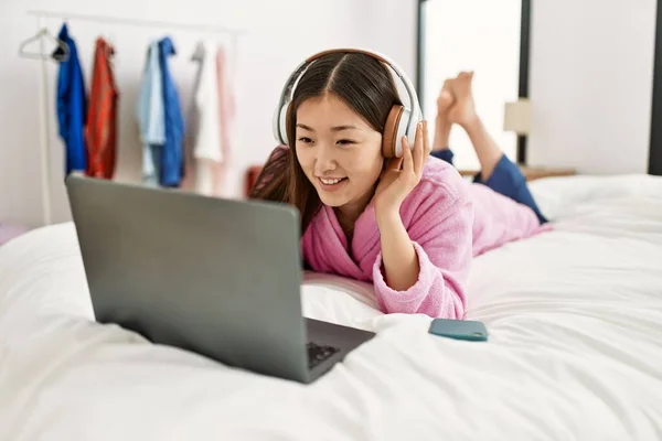 Młoda Chinka Korzystająca Laptopa Słuchawek Leżących Łóżku Sypialni — Zdjęcie stockowe