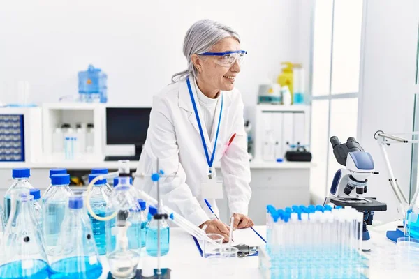 Mulher Cabelos Grisalhos Meia Idade Vestindo Uniforme Cientista Escrevendo Prancheta — Fotografia de Stock