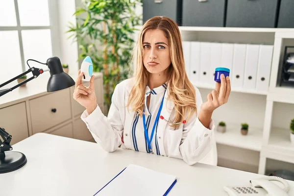 Young Blonde Doctor Woman Holding Medicine Products Breath Better Depressed — Fotografia de Stock