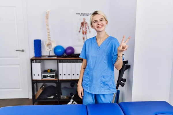 Jonge Fysiotherapeut Vrouw Werkzaam Bij Pijn Herstel Kliniek Tonen Wijzen — Stockfoto
