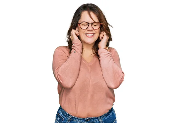 年轻又大的女人穿着休闲装 戴着眼镜 用手指捂住耳朵 对嘈杂的音乐感到恼怒 聋人概念 — 图库照片