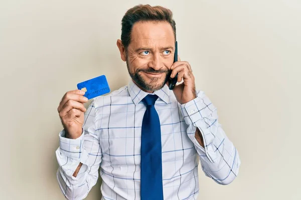 Бізнесмен Середнього Віку Розмовляючи Смартфоні Тримає Кредитну Картку Посміхаючись Дивитися — стокове фото