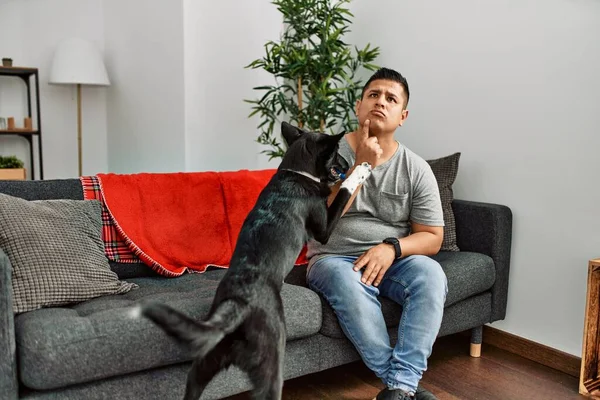Young Latin Man Dog Sitting Sofa Home Thinking Concentrated Doubt — Fotografia de Stock
