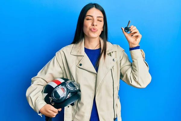 Young Hispanic Woman Holding Motorcycle Helmet Key Looking Camera Blowing — Stockfoto