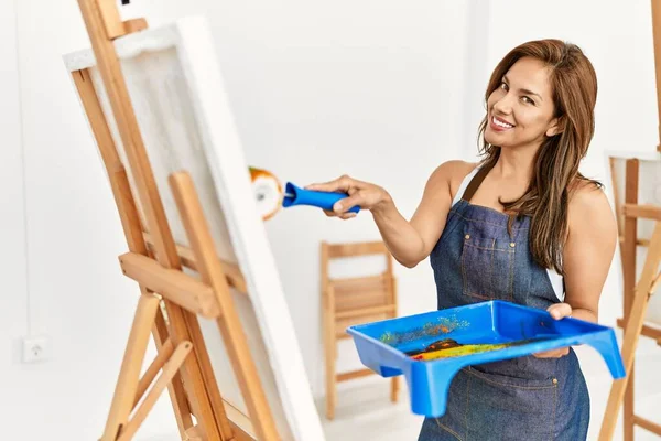 年轻的惊慌失措的艺术家女人在画室里开心地微笑着 — 图库照片