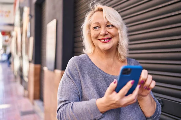 Blonde Frau Mittleren Alters Lächelt Selbstbewusst Mit Smartphone Auf Der — Stockfoto