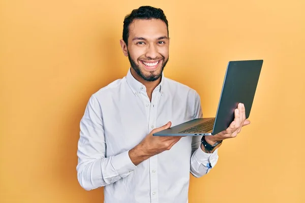 有胡子的西班牙男人用电脑笔记本电脑工作时 面带微笑 面带微笑 面带微笑 看起来很积极 很快乐 — 图库照片