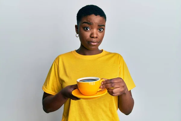 Young African American Woman Holding Coffee Skeptic Nervous Frowning Upset — Stock fotografie