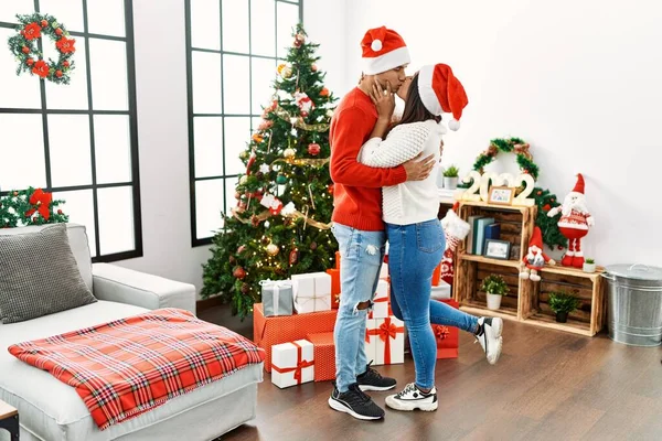 Young Latin Couple Hugging Kissing Standing Christmas Tree Home — Stok fotoğraf