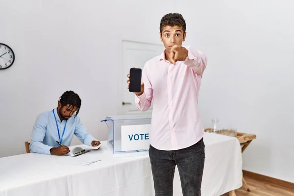 Young Hispanic Men Political Campaign Election Holding Smartphone Pointing Finger — Fotografia de Stock