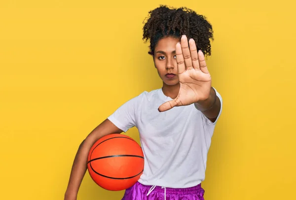 年轻的非洲裔美国姑娘拿着棒球棒和球 用张开的手做停止手势 表情严肃而自信 手势防守 — 图库照片