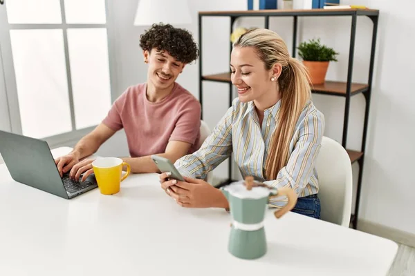 Unga Par Använder Laptop Och Smartphone Dricka Kaffe Hemma — Stockfoto