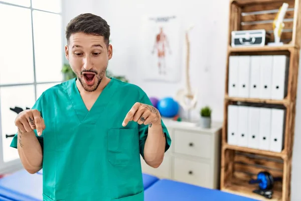 Young Physiotherapist Man Working Pain Recovery Clinic Pointing Fingers Showing — Stockfoto