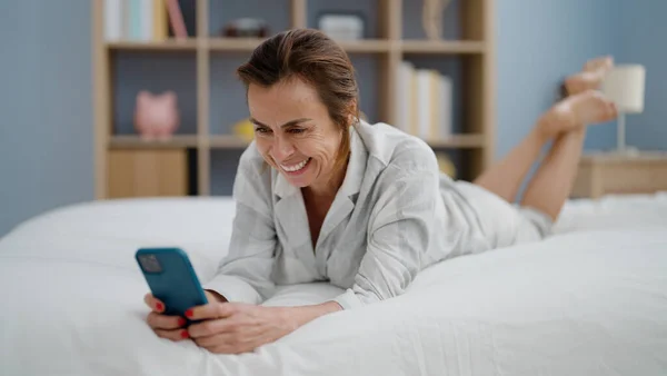 Mujer Hispana Mediana Edad Usando Teléfono Inteligente Acostado Cama Dormitorio —  Fotos de Stock