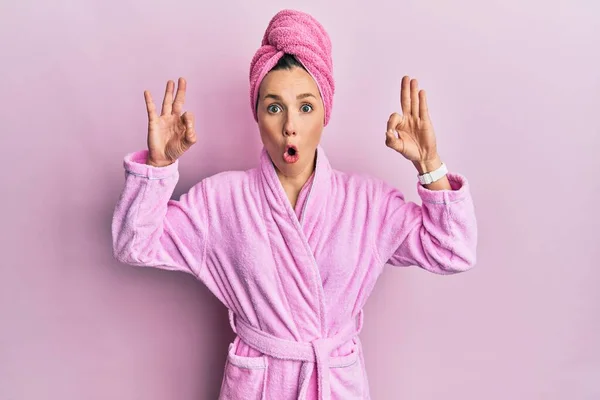 Young Blonde Woman Wearing Shower Towel Cap Bathrobe Looking Surprised — Stock Photo, Image