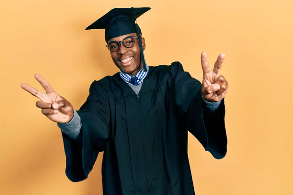 Молодий Афроамериканець Випускному Капюшоні Обрядовому Одязі Посміхається Язиком Показуючи Пальці — стокове фото