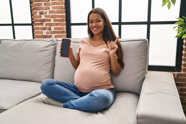 Jonge Zwangere Vrouw Met Smartphone Met Scherm Glimlachend Gelukkig Wijzend — Stockfoto