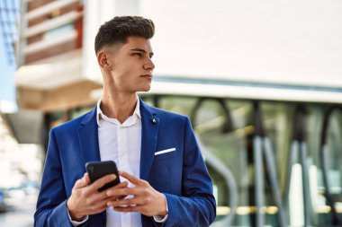 Sokakta akıllı telefon kullanan genç bir adam.