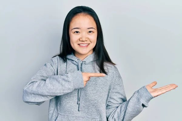 Młoda Chińska Dziewczyna Ubraniu Casual Zdumiony Uśmiechnięty Kamery Podczas Prezentacji — Zdjęcie stockowe