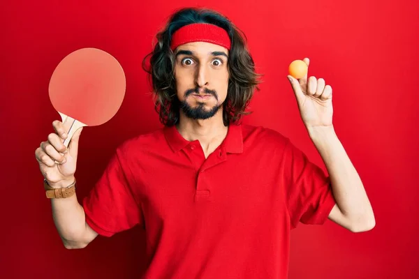 Jovem Hispânico Segurando Raquete Ping Pong Vermelho Bochechas Sopro Bola — Fotografia de Stock