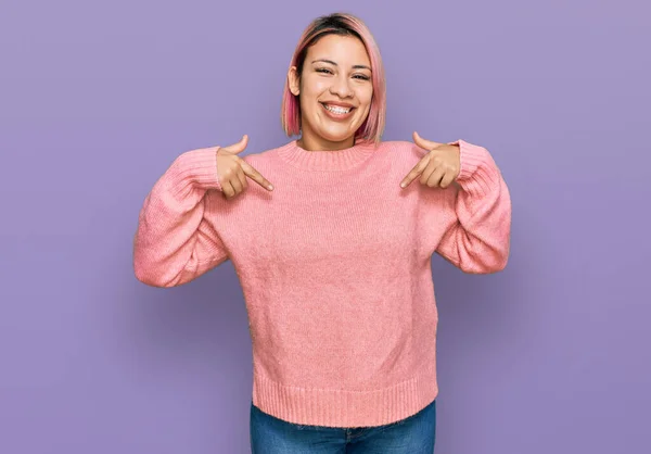 ピンクの髪をしたヒスパニック系の女性は 顔に笑顔で自信を持って見えるカジュアルな冬のセーターを着て 誇りに思って幸せな指で自分自身を指して — ストック写真