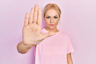 Sıradan pembe tişörtler giyen genç sarışın kadın avucunun içi gibi şarkı söylemeyi kesiyor. Yüzünde olumsuz ve ciddi bir jest olan uyarı ifadesi. 