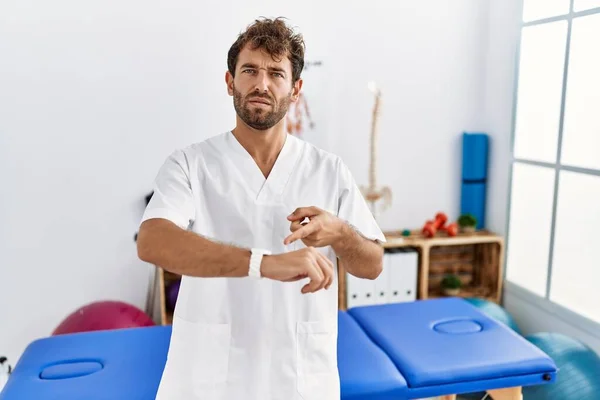 Young Handsome Physiotherapist Man Working Pain Recovery Clinic Hurry Pointing — ストック写真